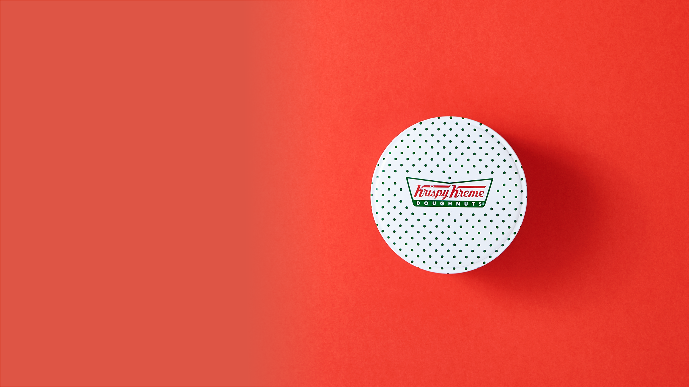 Krispy Kreme metal packaging on a red background.